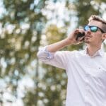 man in white polo shirt wearing blue sunglasses