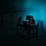 man siting facing laptop