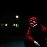 man squatting during nighttime