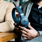 a person holding a pair of headphones in their hands