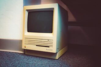 an old computer sitting on the floor next to a wall