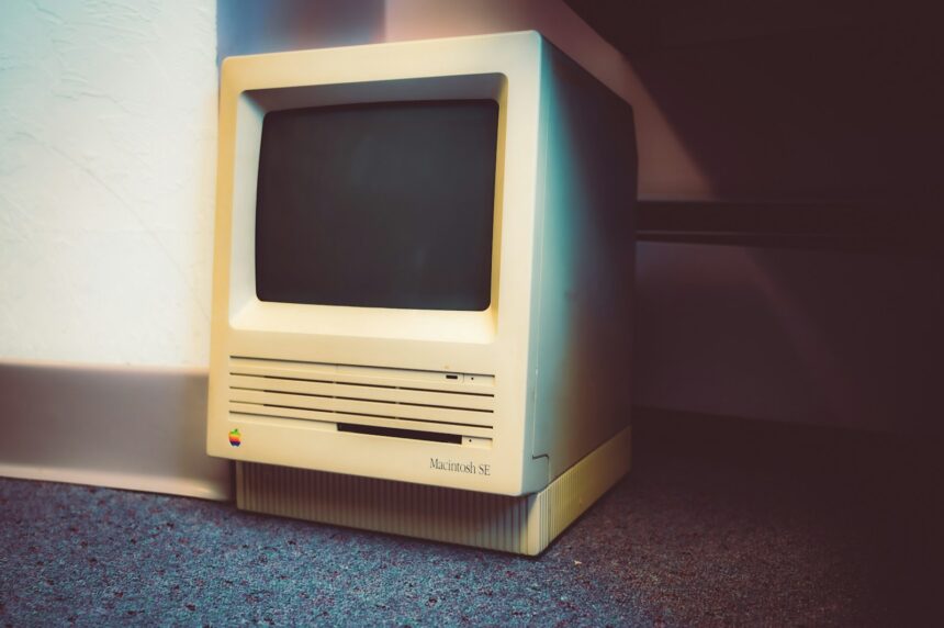 an old computer sitting on the floor next to a wall